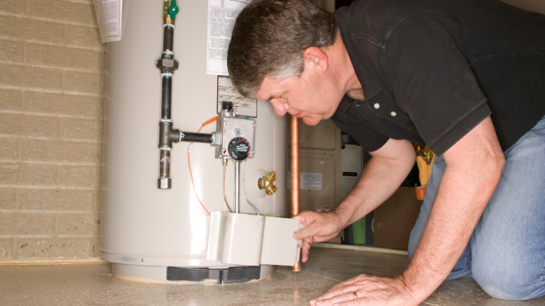 Plumber repairing drain pipe under kitchen sink during plumbing service